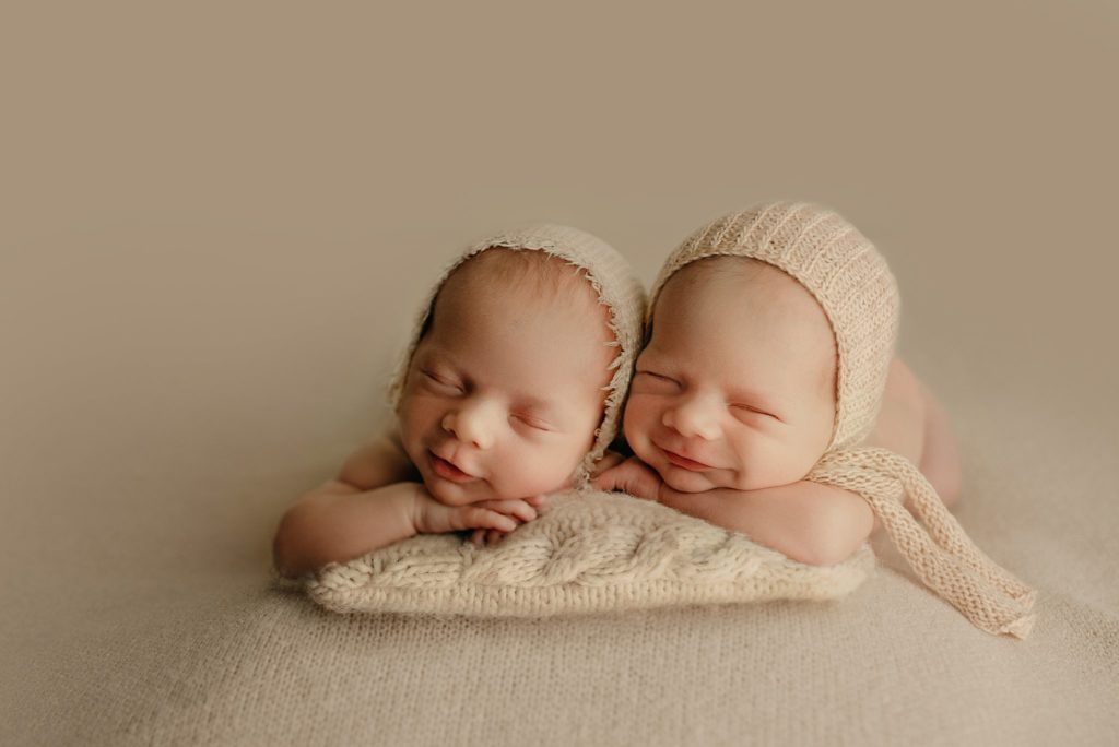 twin newborn photoshoot with head on hands